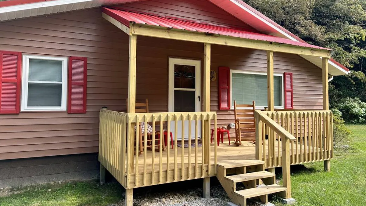 The exterior front porch of the cabin, featuring inviting rocking chairs, red shutters, and a welcoming atmosphere. The scene suggests a spot for socializing, relaxing, and enjoying the beautiful mountain scenery, while highlighting space for activities like barbecues or group gatherings.